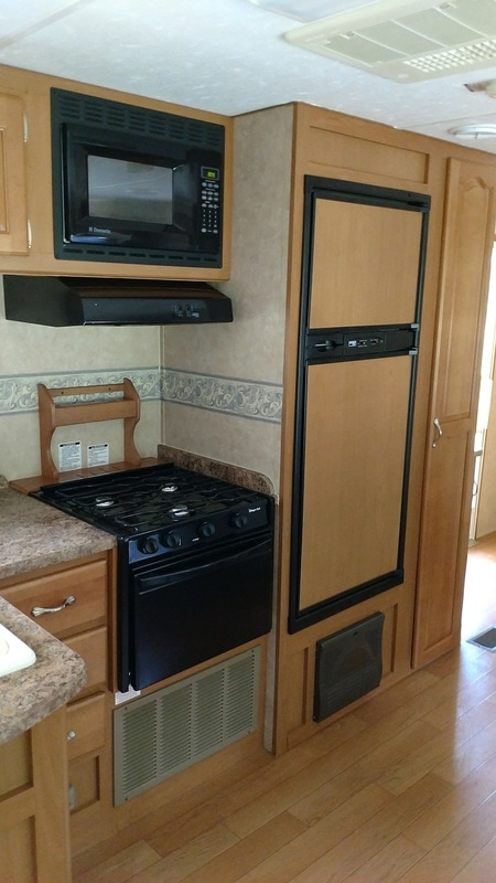 galley kitchen stove and fridge
